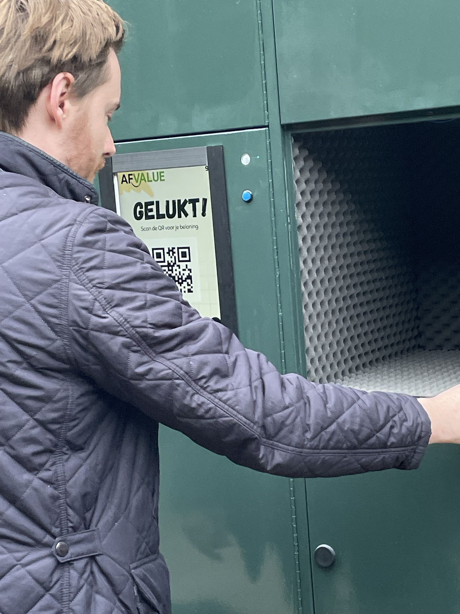 Gebruiker plaatst smartphone in de Afvalue scanner
